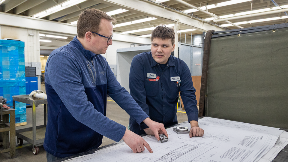 UAA student Eric Gama discusses a project with his supervisor at Allis Manufacturing, a UAA partner.