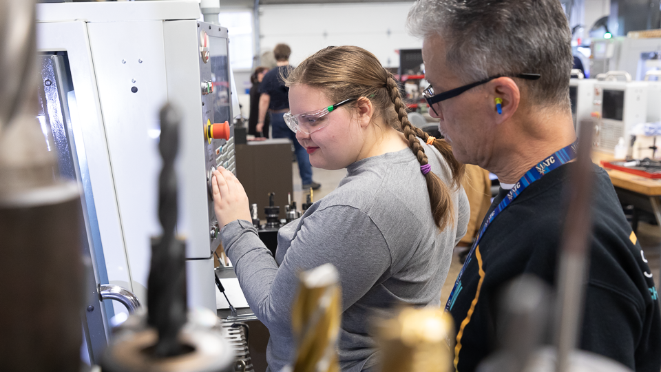 UAA student Siri Reichelt smiles while working in MATC's CNC lab.