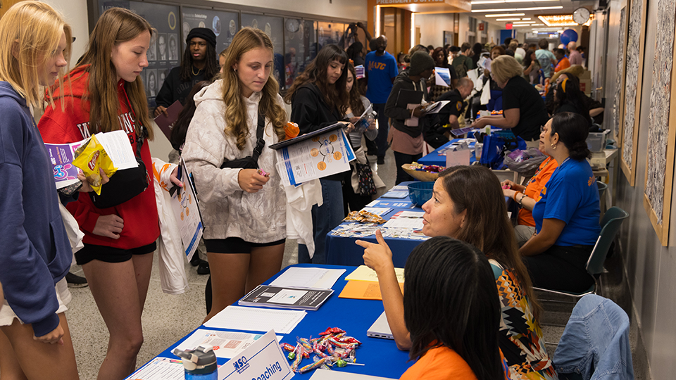students and staff at an information table