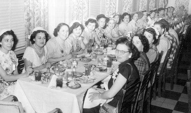 large group of women gathered at formal dinner
