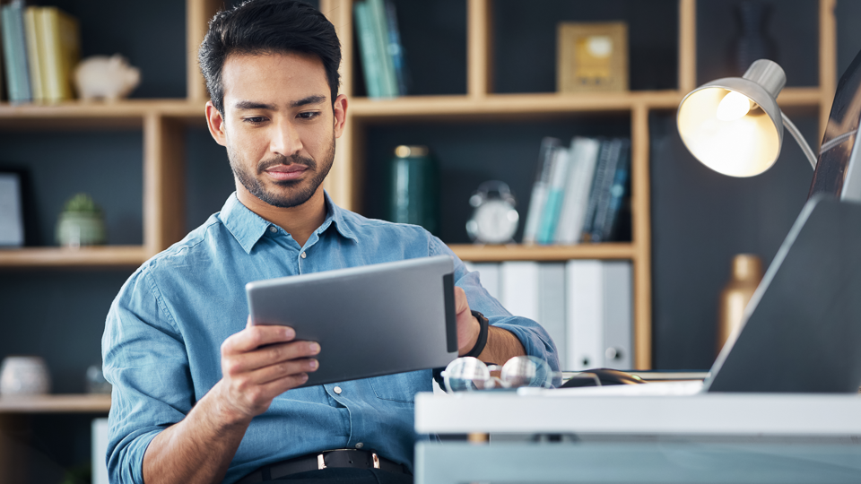 man in office looking at a tablet