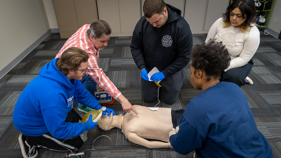 EMT students working on CPR simulator