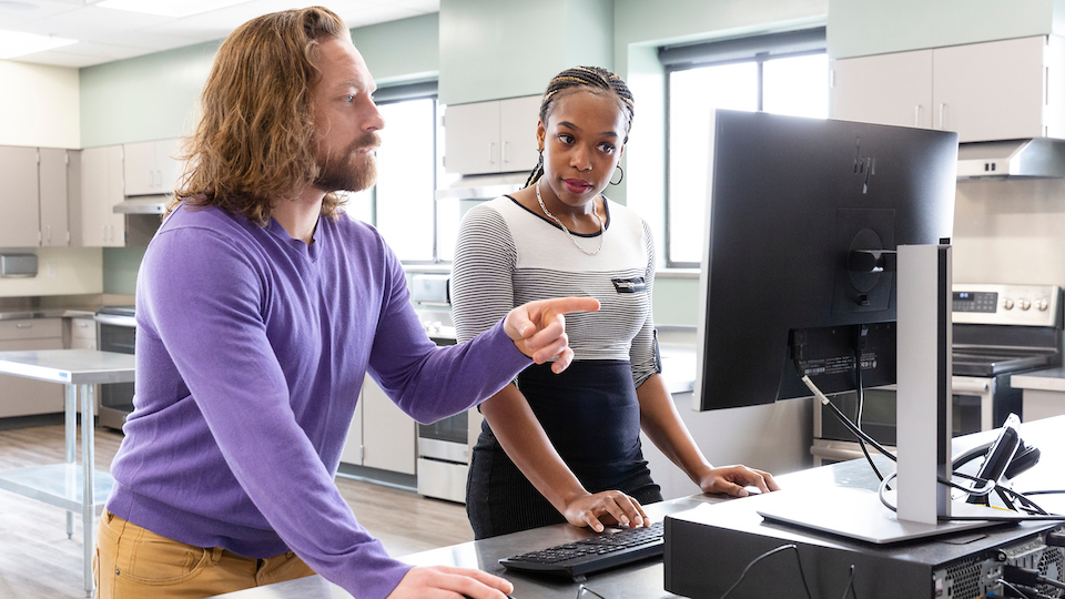 student and instructor at computer