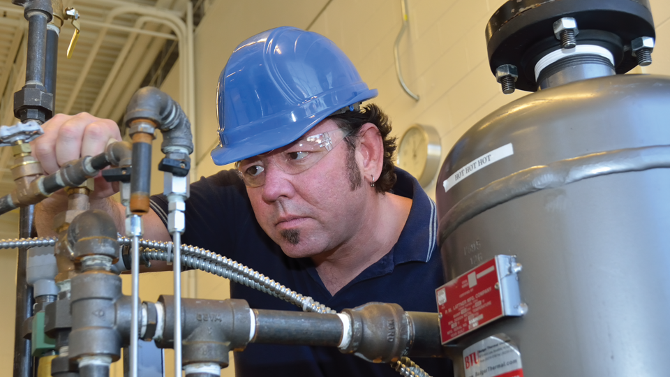 Boiler operator checking on a valve