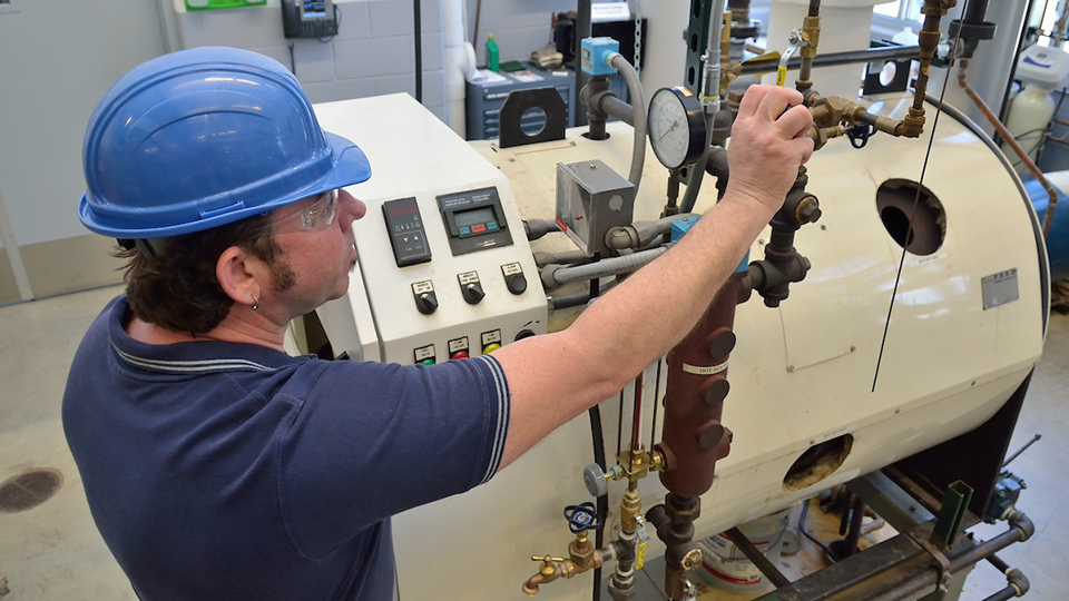 Boiler operator checking on a valve
