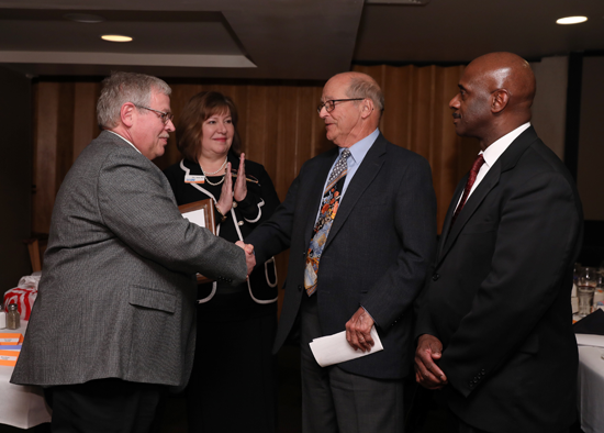 WTCS Board President S. Mark Tyler presents award to Tom Hurvis, Foundation co-founder, while MATC President Dr. Vicki J. Martin and Foundation Executive Director Nathaniel Lynn look on.  