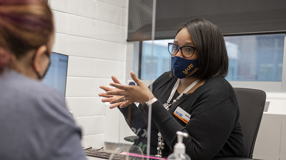 MATC employee assisting student