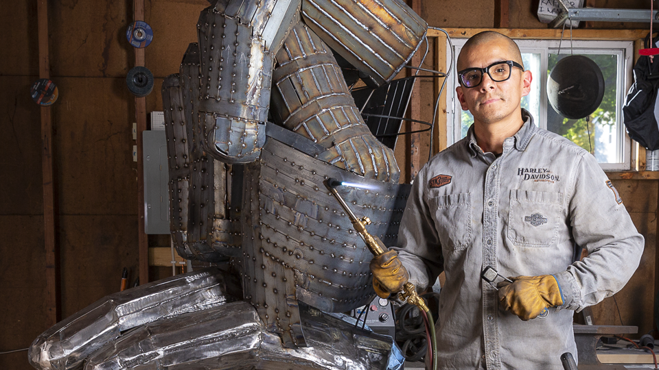 David Perez in front of MATC sign language steel sculpture