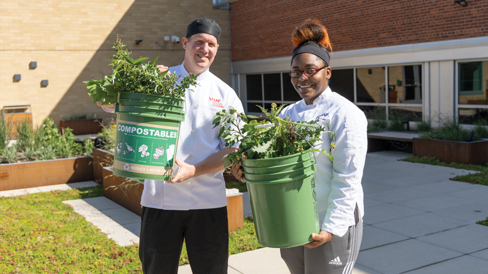 People holding buckets of kitchen scraps ready to be composted