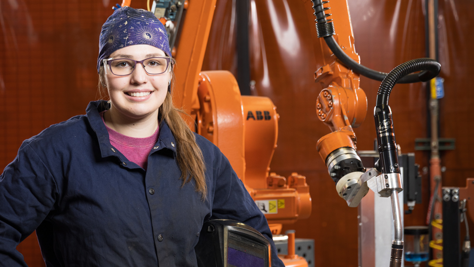 Hallee standing in front of welding machine